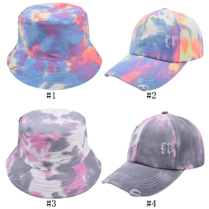 Assorted tie-dye bucket hats and baseball caps featuring vibrant pink and blue colors