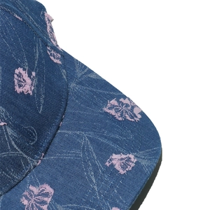 Macro detail of blue denim baseball cap with pink floral embroidery and premium stitching