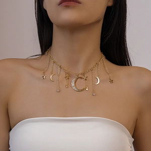 Gros plan du collier lune et étoile doré avec strass et perles porté par un mannequin