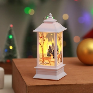 White Christmas lantern with reindeer forest scene and warm LED light on wooden table