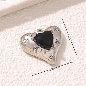 Macro detail of heart pendant with black gem, silver star motifs and tiny rhinestones