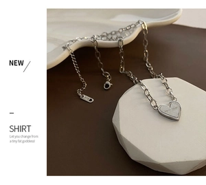 Detail of silver heart pendant engraved with Never Forget on a dual-style steel chain