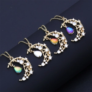 Detail view of four gold necklaces with moon, star charms and colorful crystal drops