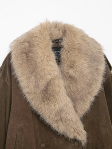 Gros plan sur une veste en daim marron avec un col luxueux en fausse fourrure beige clair