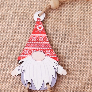 Detail of wooden Christmas gnome ornament with red hat and jute string on rustic burlap