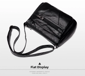 Détail de la sacoche noire en cuir PU avec coutures en V et trois poches zippées externes