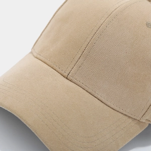 Detail view showing multi-row stitching on the brim of a beige cotton baseball cap