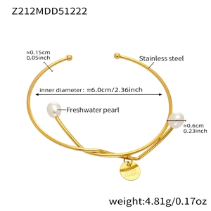 Detail of 18k gold plated stainless steel open bangle with freshwater pearls and pendant