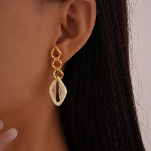 Vue détaillée du collier en or avec un pendentif géométrique blanc orné de petits cristaux