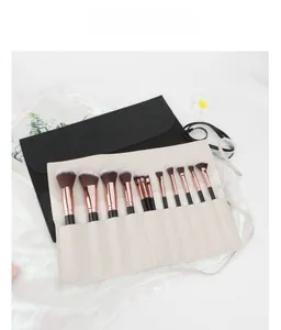 Detail of 12 professional makeup brushes with rose gold ferrules and cream leather roll bag
