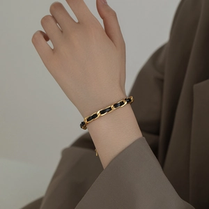 Elegant gold metal chain interwoven with black leather strap bracelet for women