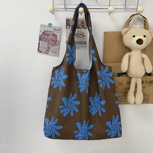 Detailed close-up of canvas tote bag featuring blue floral patterns on brown fabric