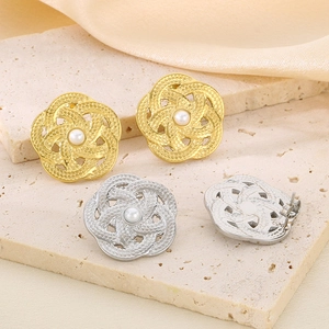 Détails de boucles d'oreilles fleur en or et argent avec perles sur tissu en soie