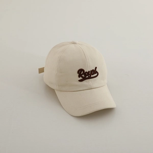 Detailed view of Royal 3D embroidery on a minimalist beige cotton baseball cap for kids