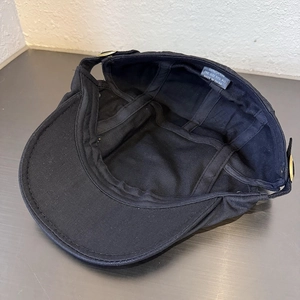 Vintage black cotton newsboy cap with rivets and internal stitching details shown