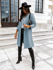 Close-up of light blue wool blend coat texture with lapel collar and button detail