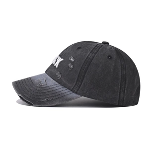 Detail of distressed TARK baseball cap with white K embroidery and worn-out effects