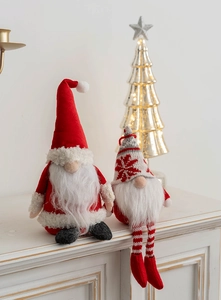 Close-up of knit Christmas gnomes with long plush beards on a white counter top