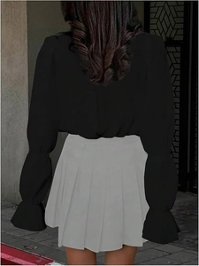 Detail of elegant lantern sleeves with ruffled cuffs on a black women's commuter shirt