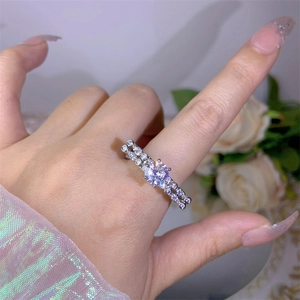 Detail of zircon silver ring on finger featuring double-row pave and large center stone