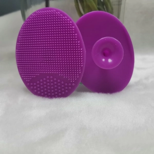 Detail of purple silicone facial cleansing brush with soft bristles and suction handle