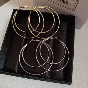 Detail view of double-layer circular shiny gold and silver hoop earrings in a jewelry box