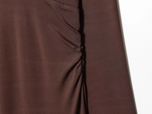 Detail shot of dark brown knitted fabric showing side ruching and texture