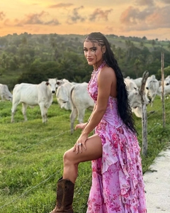Detail of floral halter dress with tiered ruffle hem and high slit in sunset ranch setting