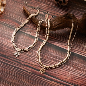 Double-layered beaded necklace with sun pendants on a vintage wood background
