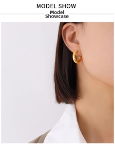 Close-up of polished gold C-shape hoop earrings showing realistic fit on a model