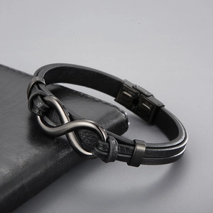 Close-up of black braided leather men's bracelet with dark grey stainless steel infinity charm