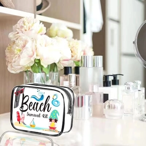 Transparent PVC makeup bag with Beach Survival Kit print on a vanity table