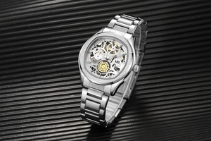 Vue latérale macro de la montre en acier argenté avec mouvement à engrenages dorés