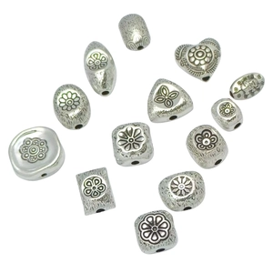 Collection of 13 silver-colored vintage metal spacer beads with engraved floral patterns