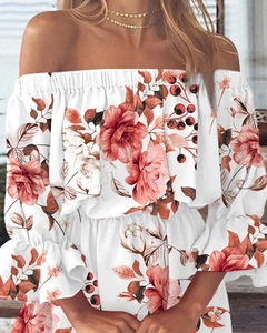 Detail van de off-shoulder halslijn en ruches op de jurk met witte bloemenprint