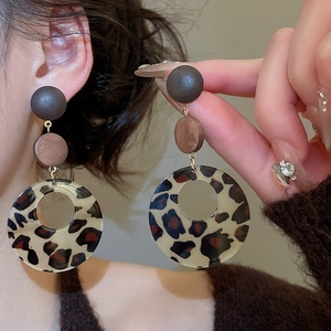 Detail view of retro leopard print resin hoop earrings with wooden bead accents