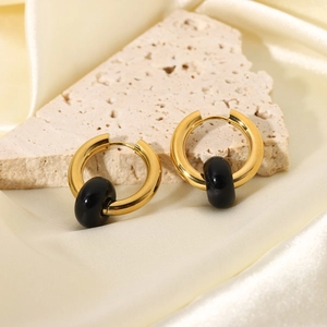 Detail of 18K gold stainless steel hoop earrings with black stone beads on silk fabric