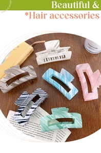 Flat lay of marble-textured rectangular hair claw clips in assorted pastel colors