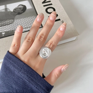925 Sterling Silver Queen Relief Coin Ring on hand against a minimalist background