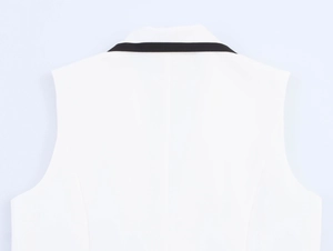 Détail de l'arrière d'un gilet sans manches blanc avec des finitions noires contrastées