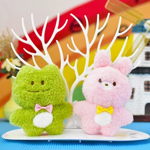 Primo piano di simpatici portachiavi in peluche a forma di rana e coniglio con fiocchi
