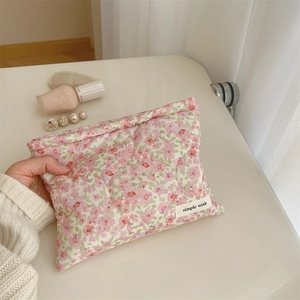 Detail of pink floral quilted cotton makeup bag with a minimalist woven label