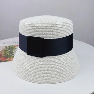 Detailed top-down shot of white woven straw sun hat with classic wide black ribbon decoration