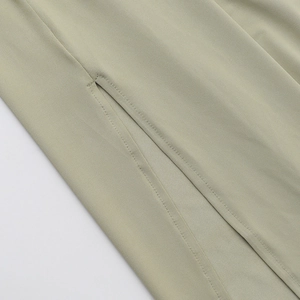 Detaillierte Makroansicht der präzisen Nähte am hellgrünen, schmalen Strickkleid-Stoff