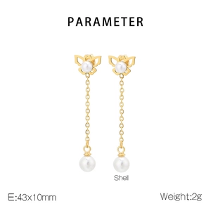 Detail of gold butterfly tassel earrings with shell pearls and elegant long metal drop design