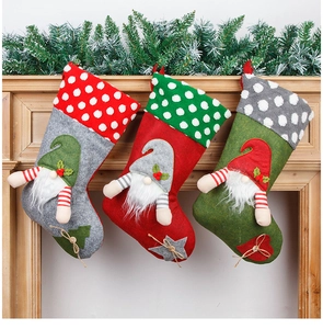 Detailed view of grey, red, and green Christmas gnome stockings on a wooden mantle