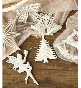 White glitter Christmas ornaments featuring angels, stars, and bells on a rustic wood surface
