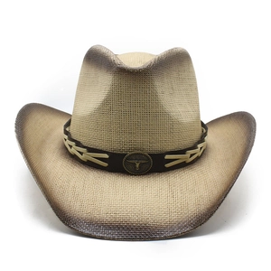 Detailed view of straw cowboy hat with a bronze bull head emblem and leather band