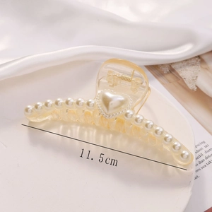 Close-up of 11.5cm champagne claw clip featuring elegant pearls and heart-shaped accent