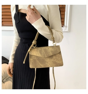 Détail d'un sac porté épaule en PU kaki vintage avec poignée nouée et anneaux métalliques